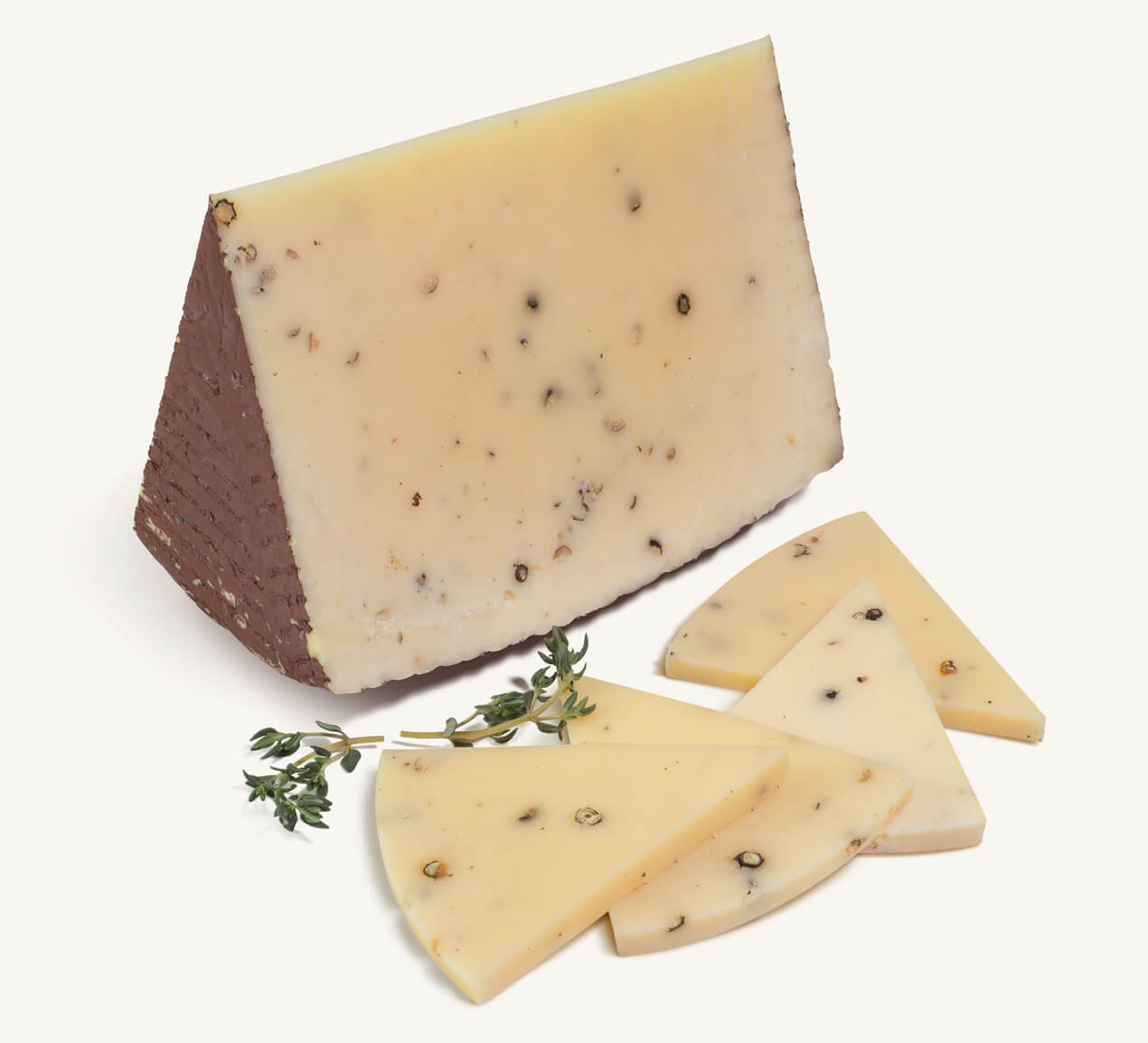 queso-canestrato-pimienta-trozo Trozo de queso Canestrato con granos de pimienta negra, acompañado de rebanadas finas y ramitas de tomillo